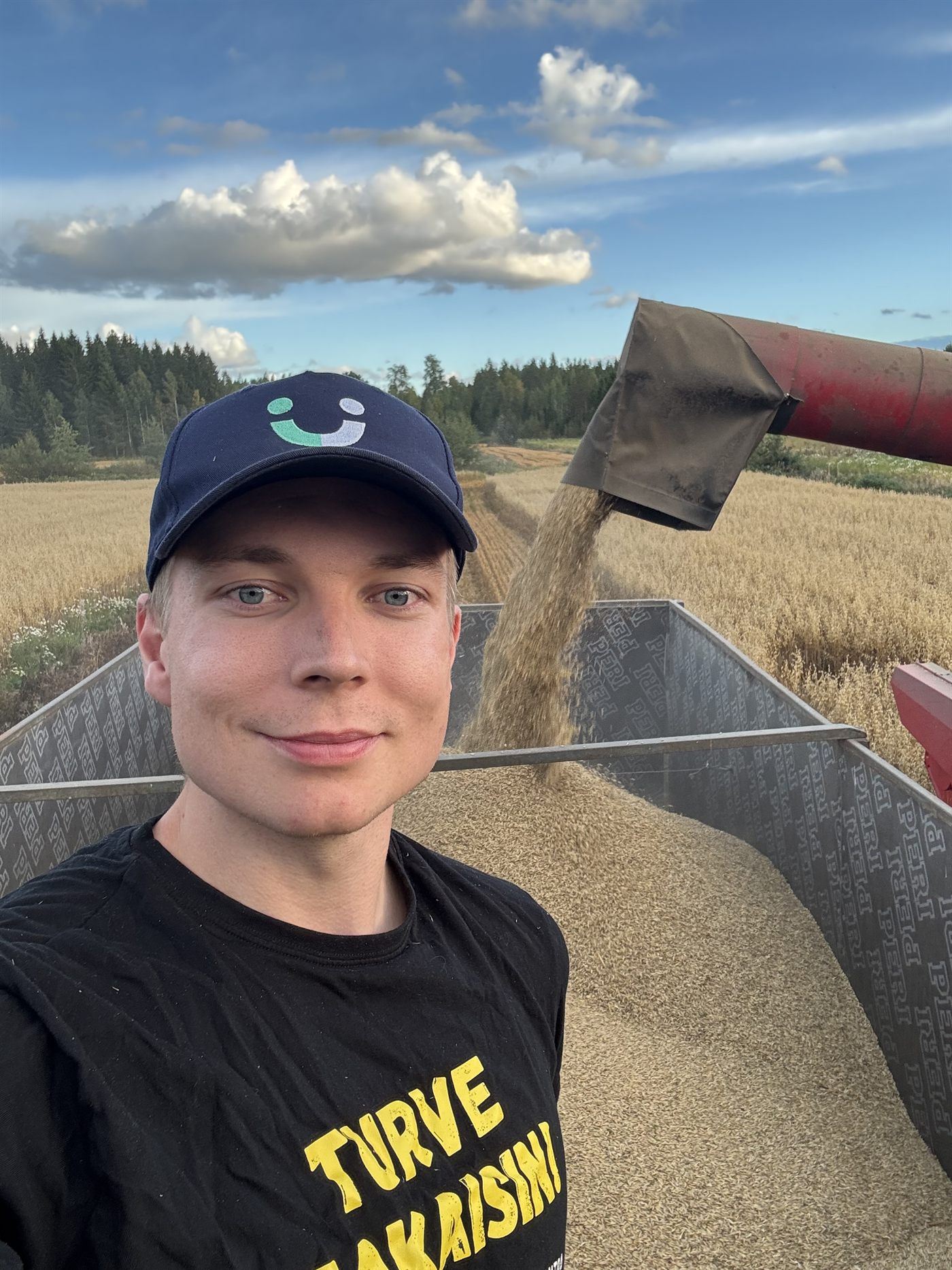 Antti Tuomela puintitöissä viljakärryn vieressä